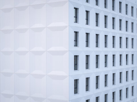 Aerial view of the modern white facade with geometric textures and repetitive window patterns on a building in Krakow, Lesser Poland Voivode, Poland.