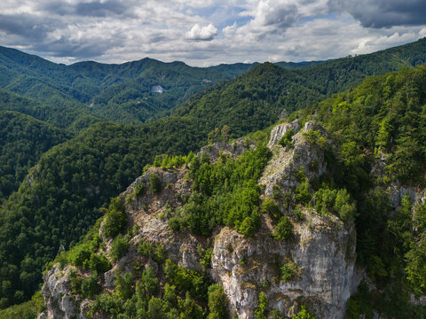 Aerial view of rocky formations above Bystricka dolina in the Velka Fatra mountains, surrounded by dense green forests in Dolny Harmanec, Banskobystricky kraj, Slovakia.