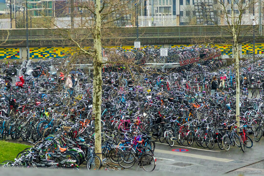 View of a vast bicycle parking area filled with hundreds of parked bicycles in an urban setting in the Netherlands.