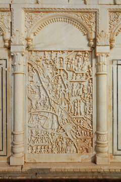 View of intricate marble relief carvings depicting mythological figures and scenes within a classical architectural frame at Sadhu Bela Mandir in Rohri, Sindh, Pakistan.