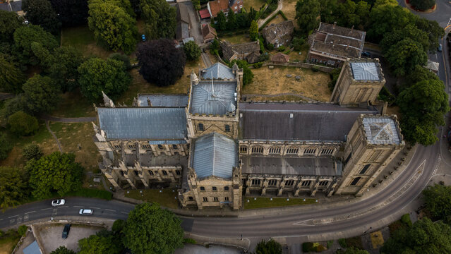 Aerial view of Ripon Cathedral with its historic stone architecture, grey slate roofs, and surrounding green grounds in Ripon, England, United Kingdom.