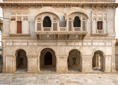 View of the intricate white marble facade and detailed carvings of the historic Sadhu Bela Mandir temple complex in Rohri, Sindh, Pakistan.