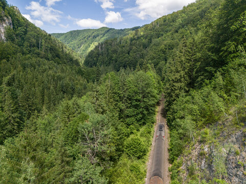 Aerial view of a train traveling through the dense forests of Bystricka dolina in Velka Fatra, Dolny Harmanec, Banskobystricky kraj, Slovakia.