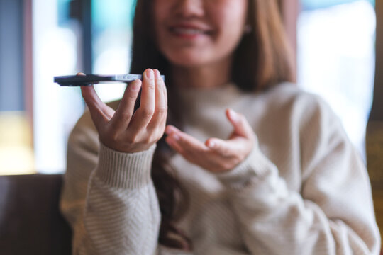 Closeup of a woman holding smart phone and using voice messaging, talking with ai assistant for Artificial intelligence concept