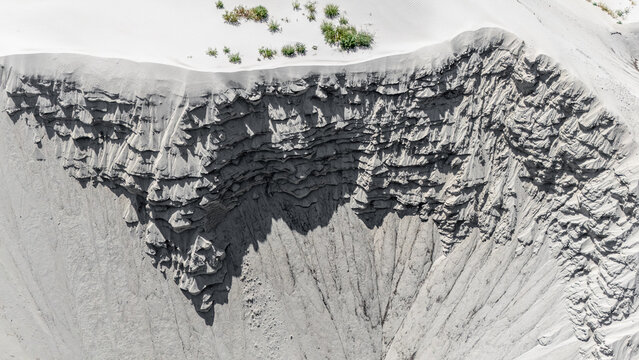 Aerial view of the sandy terrain with eroded cliff-like formations and sparse green vegetation in Novi Sad, Vojvodina, Serbia.