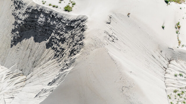 Aerial view of sand dunes with textured slopes and sparse vegetation in Novi Sad, Vojvodina, Serbia.