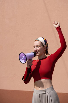 Woman raises fist and speaks through megaphone