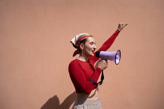 Woman points up while giving speech through megaphone