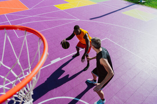 Male athlete dribbles basketball on a colorful urban court
