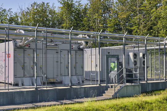 Nordborg, Denmark - 12 July 2026: View of Danfoss Campus modular data center with energy-efficient server units and heat recovery pipes in a fenced outdoor facility.