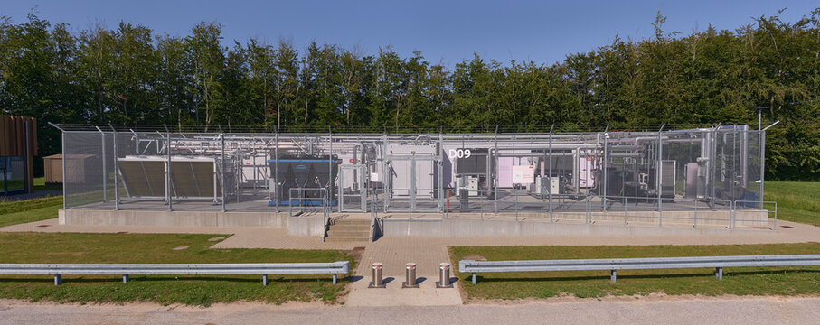 Nordborg, Denmark - 12 July 2026: View of the Danfoss Campus modular data center with server units designed for sustainable waste heat recovery, set against a forest edge.