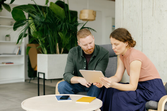 Businessman and businesswoman use a tablet in a coworking space