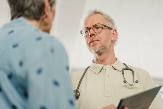 Doctor listens to woman during medical consultation inside