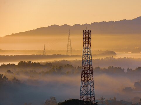 View of telecommunication towers rising above a misty landscape at sunrise in Nhila, Teknaf, Cox's Bazar, Chittagong Division, Bangladesh.