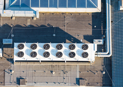 Aerial view of an industrial HVAC cooling unit with multiple circular fans installed on a flat roof in the Oliwa district of Gdansk, Pomeranian Voivodeshi, Poland.
