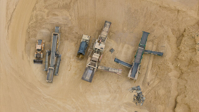 Aerial view of aggregates quarry and mining site with heavy machinery, conveyor belts, and industrial equipment in Little Ponton, England, United Kingdom.