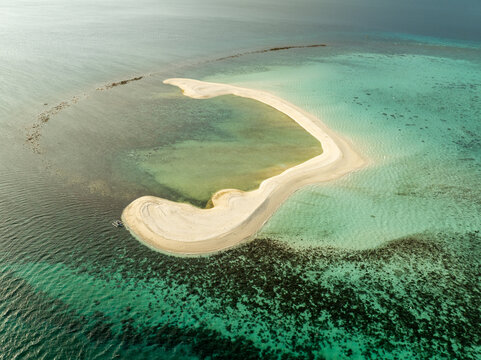 Aerial view of White Island, a pristine sandbar surrounded by turquoise waters and coral reefs in Mambajao, Camiguin, Philippines.