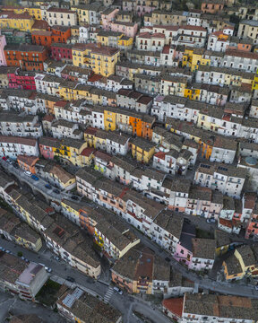 Aerial view of the colorful historic town featuring dense clusters of traditional stone houses with terracotta roofs and narrow winding streets in Calitri, Campania, Italy.