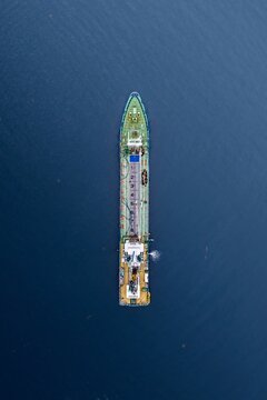 Aerial view of a cargo ship navigating the deep blue waters off the coast of Numazu, Shizuoka, Japan.
