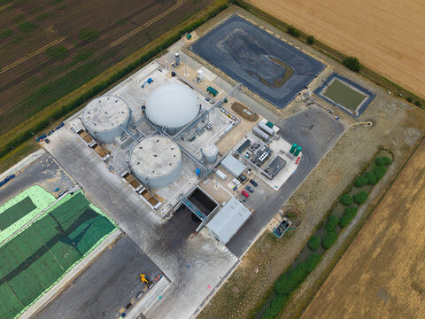 Aerial view of the Moor Bio Energy facility featuring large anaerobic digester tanks and industrial infrastructure surrounded by agricultural fields in Grantham, England, United Kingdom.