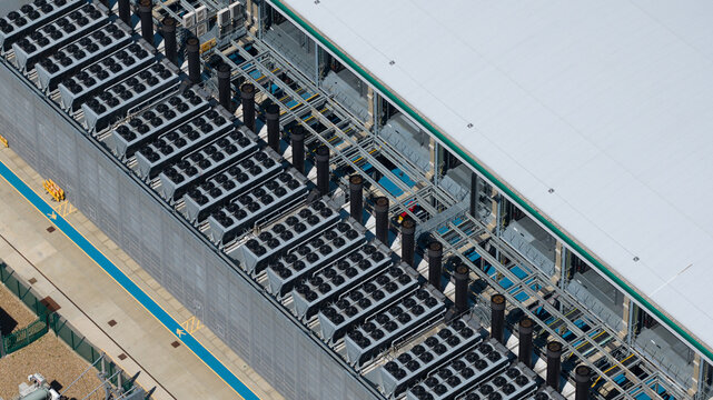 Aerial view of a data center rooftop featuring rows of industrial cooling fans and ventilation systems in Hemel Hempstead, England, United Kingdom.