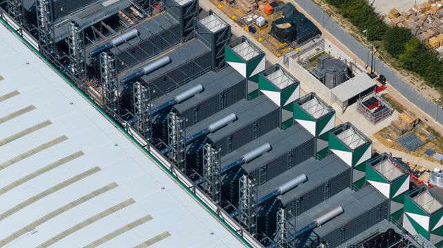Aerial view of industrial cooling units and technical infrastructure on the roof of a large data center facility with metal framework in Hemel Hempstead, England, United Kingdom.