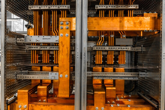 View of copper busbars and electrical components inside an industrial switchgear cabinet in Latvia.