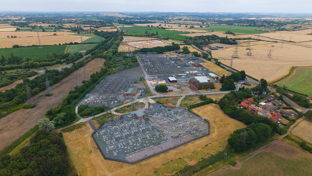 Aerial view of Staythorpe Power Station electrical substation surrounded by rural fields and power lines in Staythorpe, England, United Kingdom.
