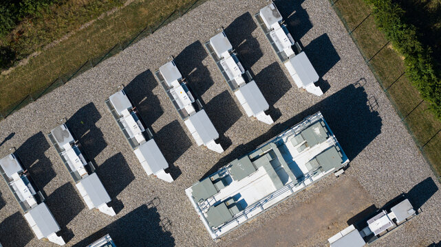 Aerial view of the Pelham Storage Limited battery energy storage facility, featuring rows of white industrial containers on a gravel lot in Bishop's Stortford, England, United Kingdom.