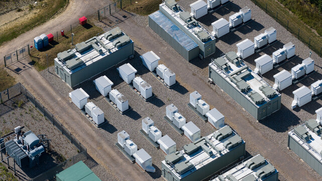 Aerial view of Pelham Storage Limited battery storage facility with rows of white containers and electrical infrastructure in a fenced site in Bishop's Stortford, England, United Kingdom.