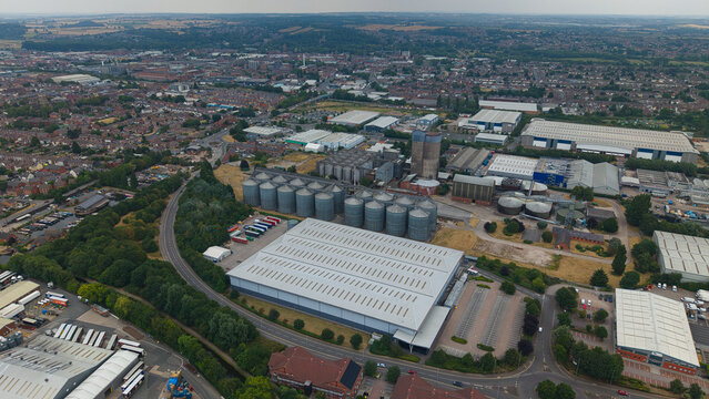 Aerial view of the industrial area in Burton upon Trent, featuring large grain silos, warehouses, and surrounding urban landscape in Burton upon Trent, England, United Kingdom.