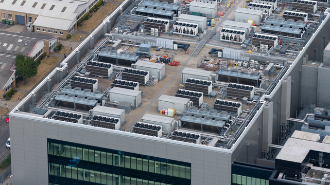 Aerial view of the rooftop of a large industrial building featuring numerous HVAC cooling units and ventilation systems in Slough, England, United Kingdom.