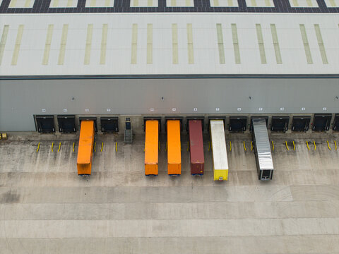 Aerial view of a logistics warehouse loading dock with multiple parked semi-truck trailers and shipping containers at Hilliard's Cross, England, United Kingdom.