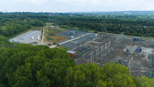 Aerial view of National Grid Bustleholme Substation featuring a battery energy storage system, electrical infrastructure, and power lines near woodland in Walsall, England, United Kingdom.