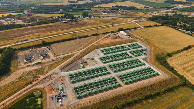 Aerial view of the National Grid Hams Hall Battery Energy Storage Systems featuring rows of green lithium ion cell containers in a rural landscape near Birmingham, England, United Kingdom.