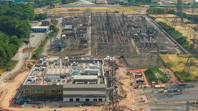 Aerial view of the National Grid Hams Hall Substation under construction with power lines and industrial infrastructure in Birmingham, England, United Kingdom.