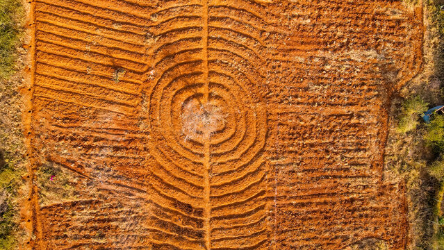 Aerial view of agricultural land featuring concentric circular patterns in the red soil, highlighting sustainable farming techniques and land cultivation in Kajiado County, Kenya.