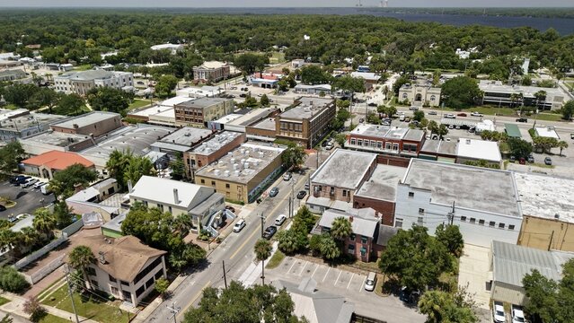Aerial view of the historic downtown area of Palatka, featuring commercial buildings, rooftops, and tree-lined streets near the St. Johns River in Palatka, Florida, United States.