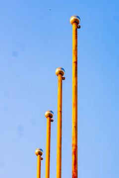 Lusaka, Lusaka Province, Zambia - 01 July 2026: View of four vertical poles with metallic spherical finials set against a clear blue sky.