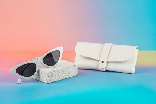 Sunglasses, fashion eyewear, and a glasses case against a colorful background.