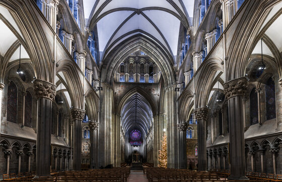 Trondheim, Norway - 30 December 2024: View of Nidaros Cathedral interior featuring gothic arches, stone columns, stained glass windows, and a Christmas tree in the nave.