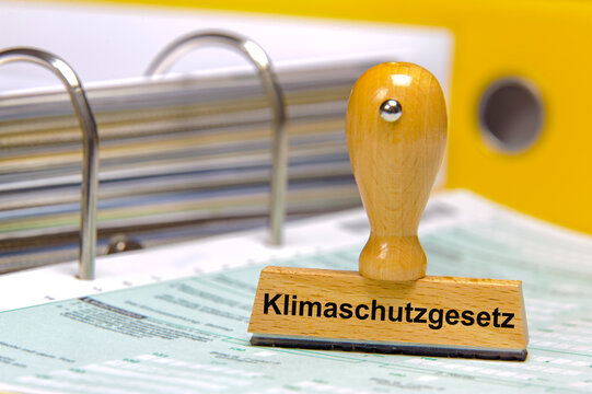 Ein Holzstempel ist beschriftet mit dem Aufdruck: Klimaschutzgesetz