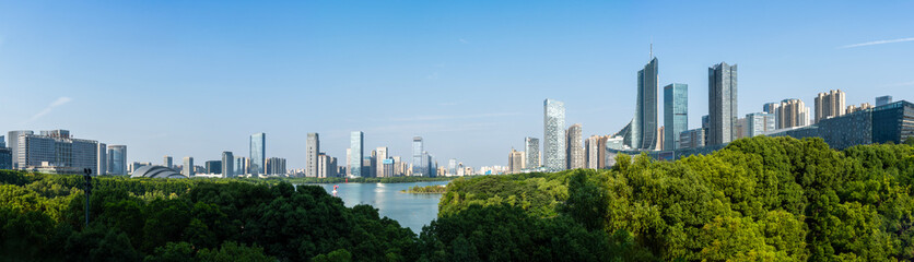 Fototapeta premium The scenery of Swan Lake in Hefei, Anhui Province, China. Xindi Center and Hefei Radio & Television Center Building stand in the distance, both being landmark buildings of Hefei.