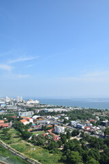 Fototapeta premium High angle vertical aerial view of coastal town, buildings, green trees, and sea view in Thailand