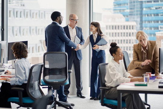 Professionals shake hands during a meeting in a London office