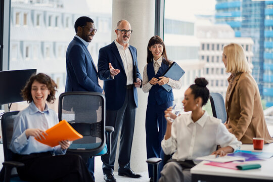 Business colleagues discuss work in a busy London office