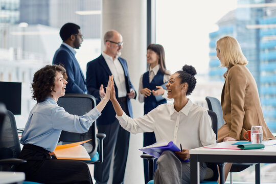 A businesswoman celebrates success with a colleague at the office