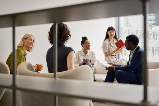 Business colleagues discuss work during a meeting in a London office