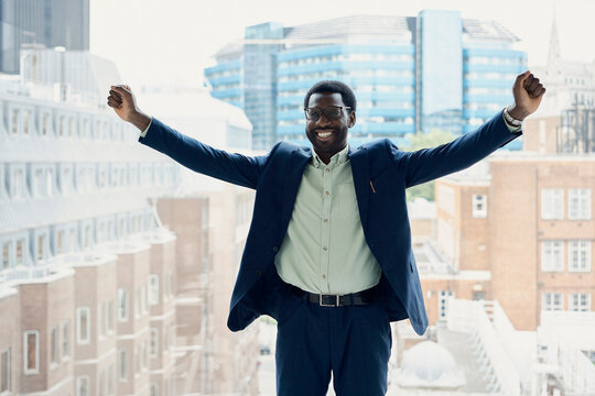 Smiling businessman celebrates success at the office in London