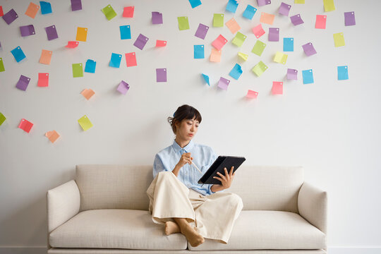 Woman works on a tablet on an office couch in London